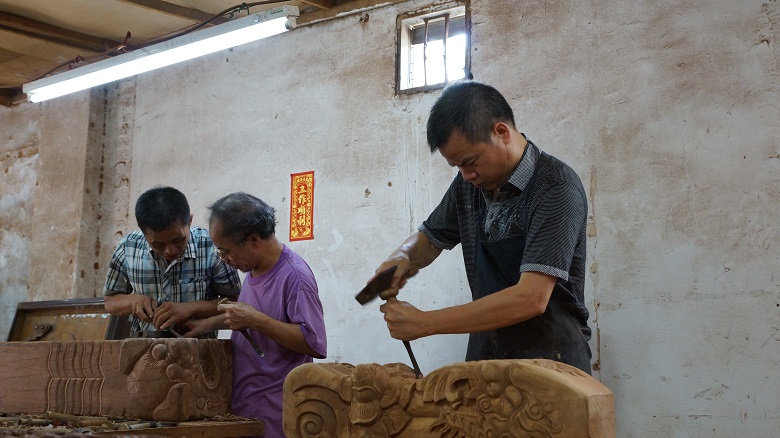 李泽添正在红木家具雕刻.jpg