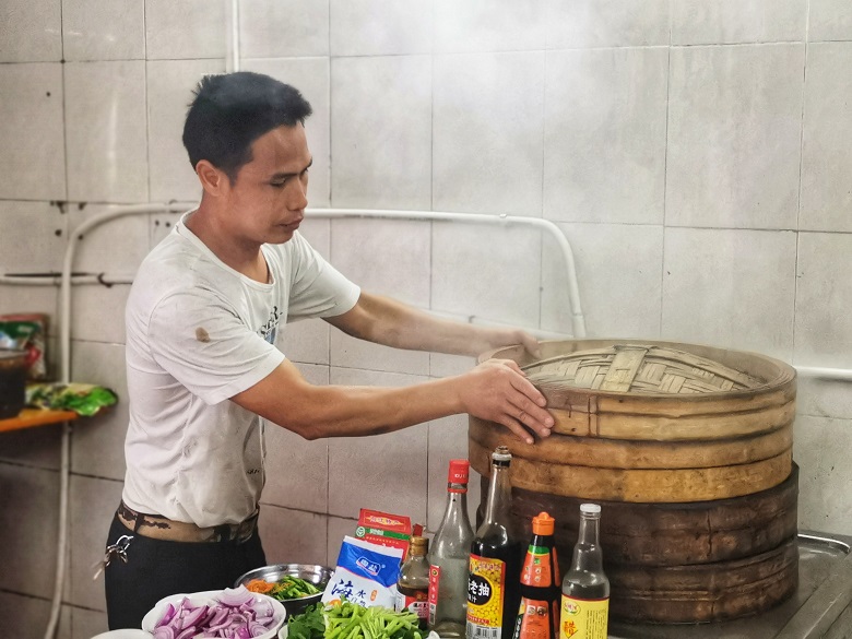 伍荣业在“粤菜师傅”创业店内忙碌中.jpg