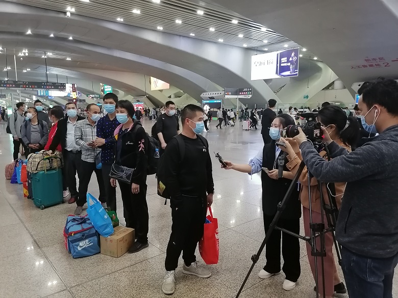 相片2、返岗人员接受媒体采访.jpg