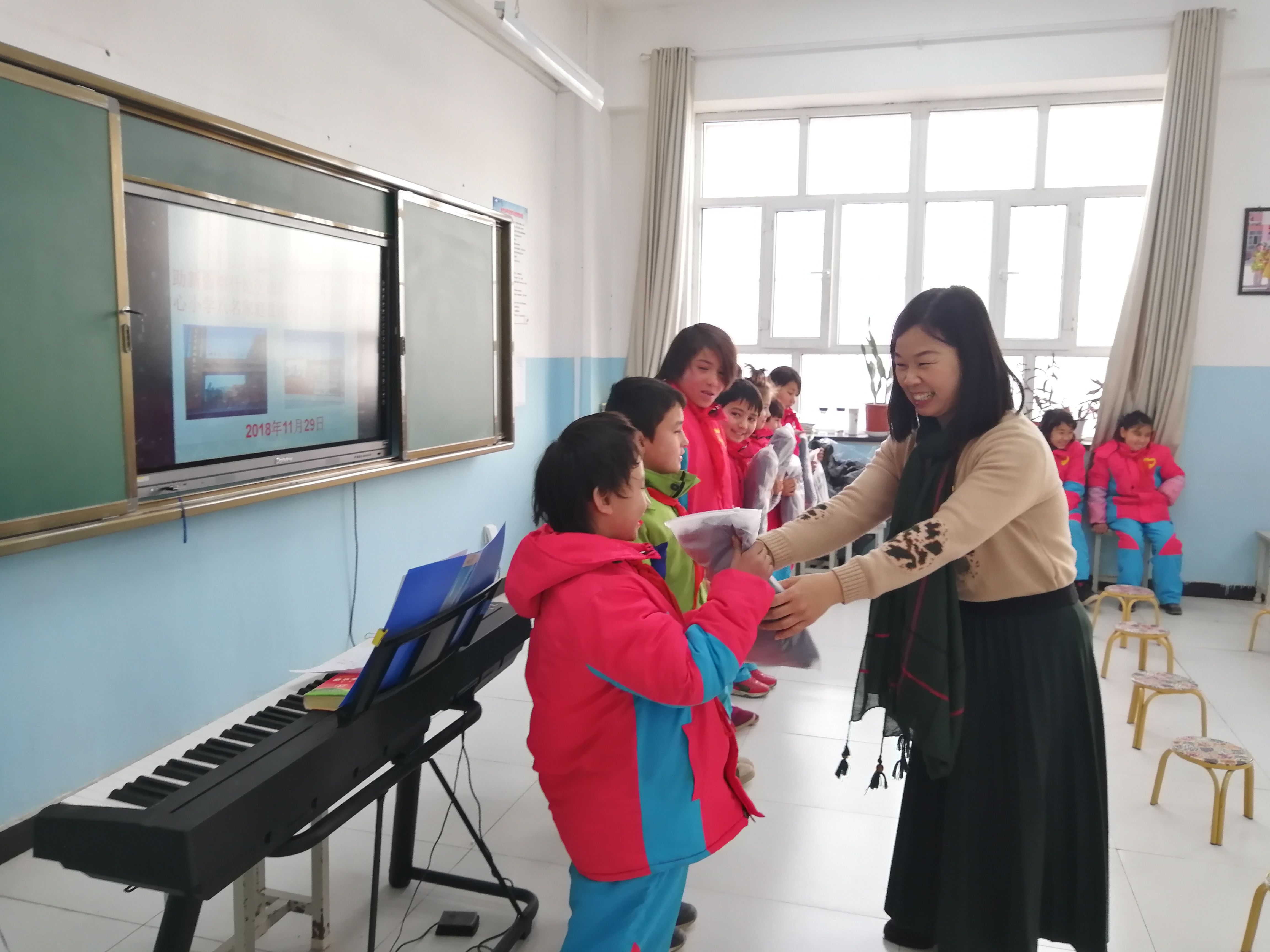 9受广东学校领导委托代表恩城一小给托小贫困学生赠送合唱服.jpg