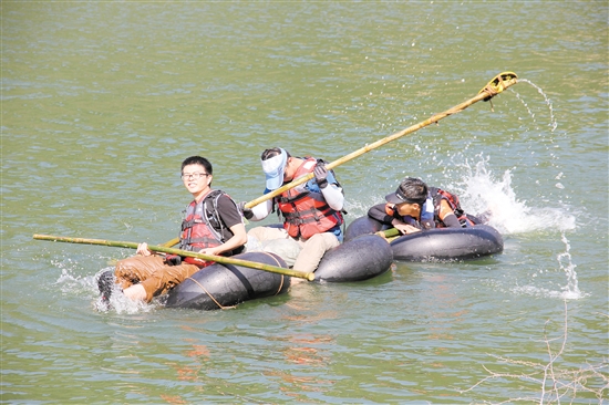 参赛选手扎好筏后，齐心协力划向终点。