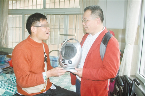 社工将热心读者叶先生捐赠的暖风机交给了叶叔（左）。