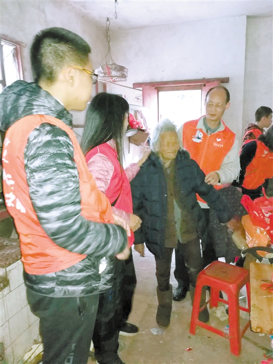 老人穿上义工送来的新衣服后很高兴。