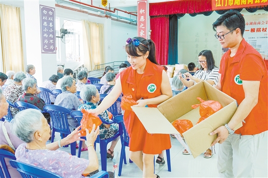 商会工作人员给现场老人送上礼物。