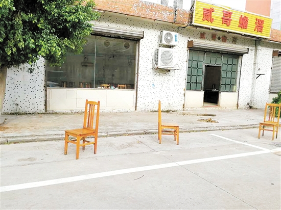 公共停车位被商家用椅子霸占。
