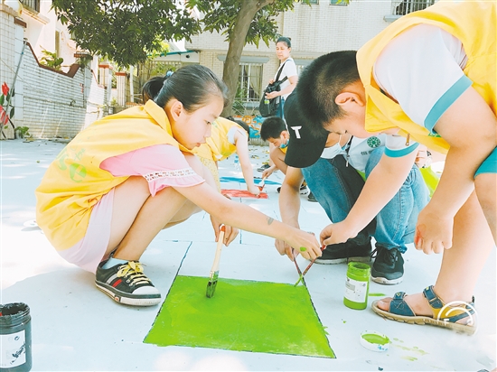 孩子们用手中的画笔，为社区小广场添色。